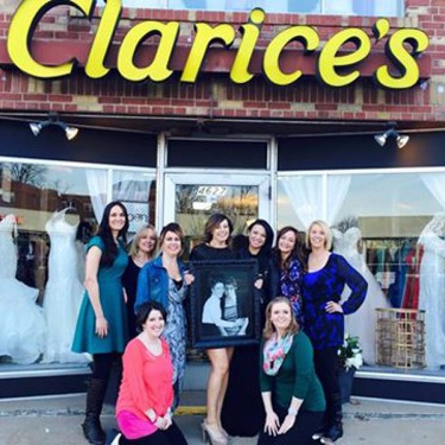 Holding a picture of store founders Susan and Clarice Caito, the staff of Clarices Bridal celebrates the opening of the new south county location Thursday.