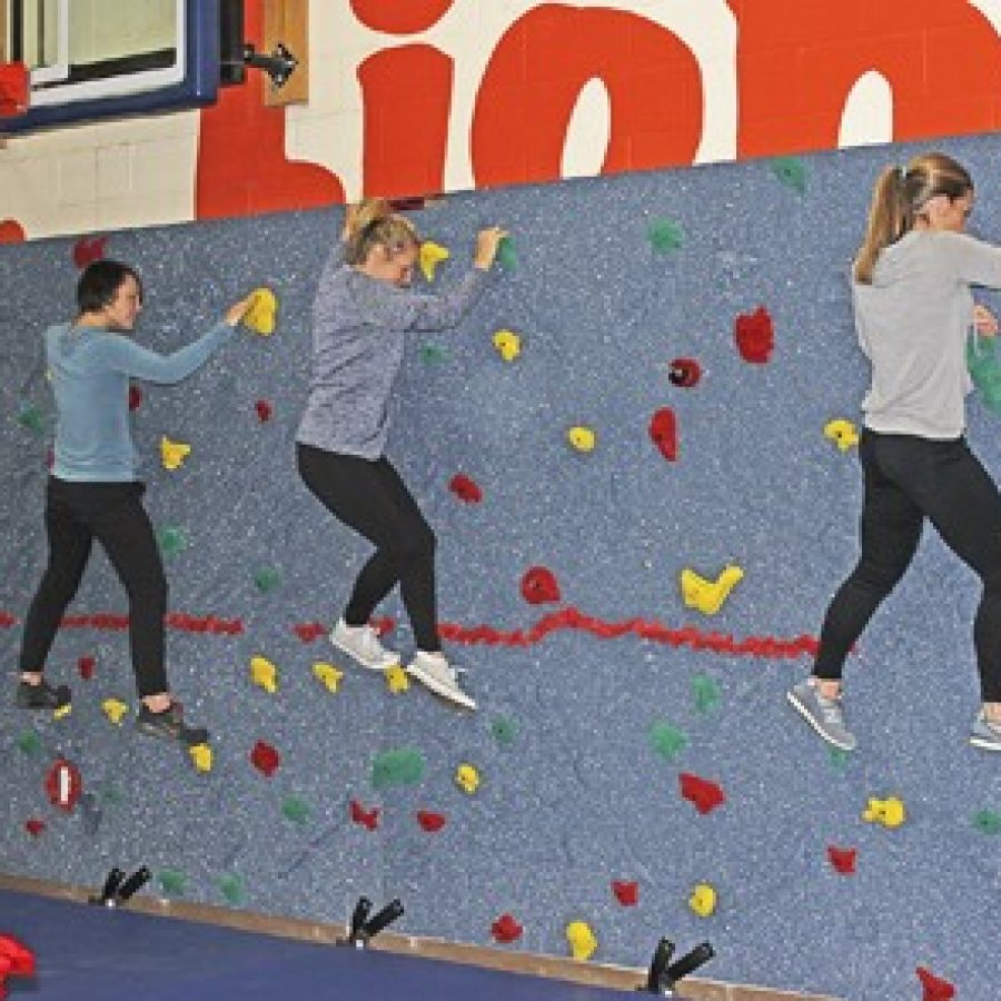 Oakville Elementary School teachers try out the schools new rock-climbing wall.
