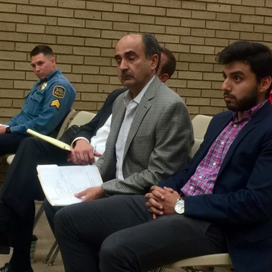 Sunset Hills Econo Lodge owner Shaiq Amir, center, is shown with his son Saad Amir, right, at Tuesday nights Board of Aldermen public hearing. Also pictured is police Sgt. Jeff Senior, left.