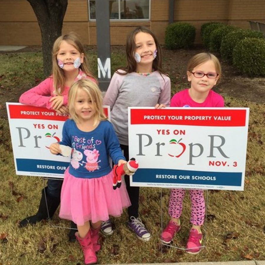 Oakville Elementary students stand outside their school with Prop R signs on Election Day last year.