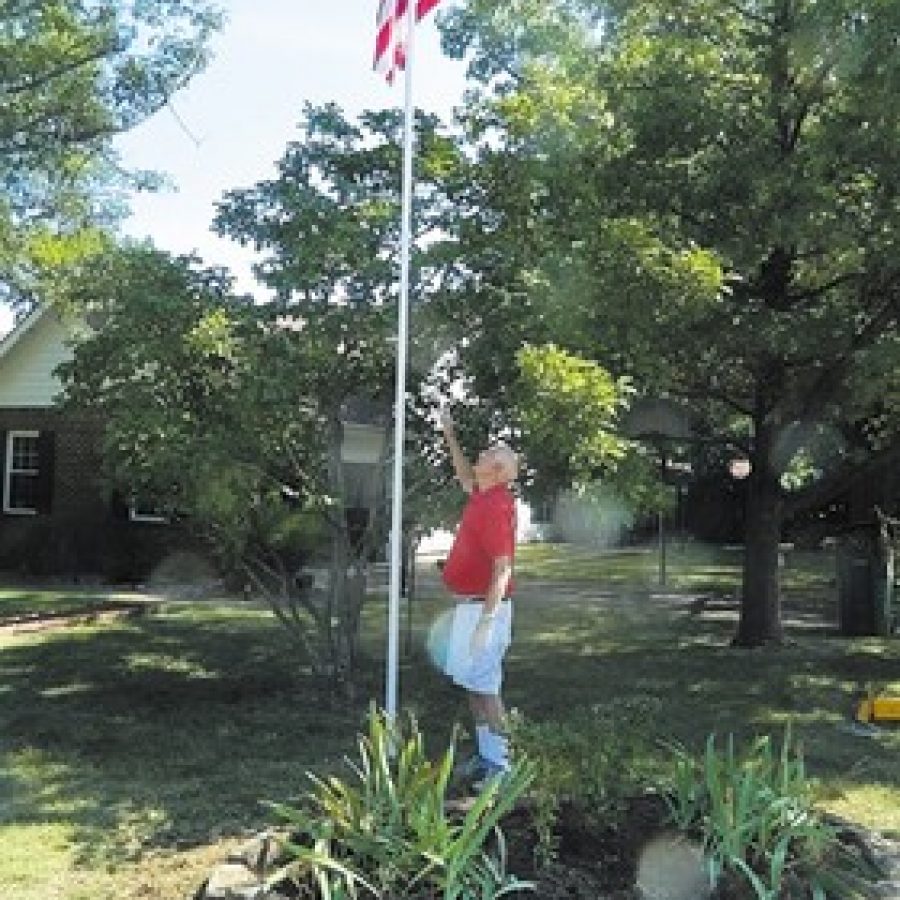 Crestwood Army veteran Gene Mentel salutes the flag flying on his flagpole that was restored by his neighbors. 