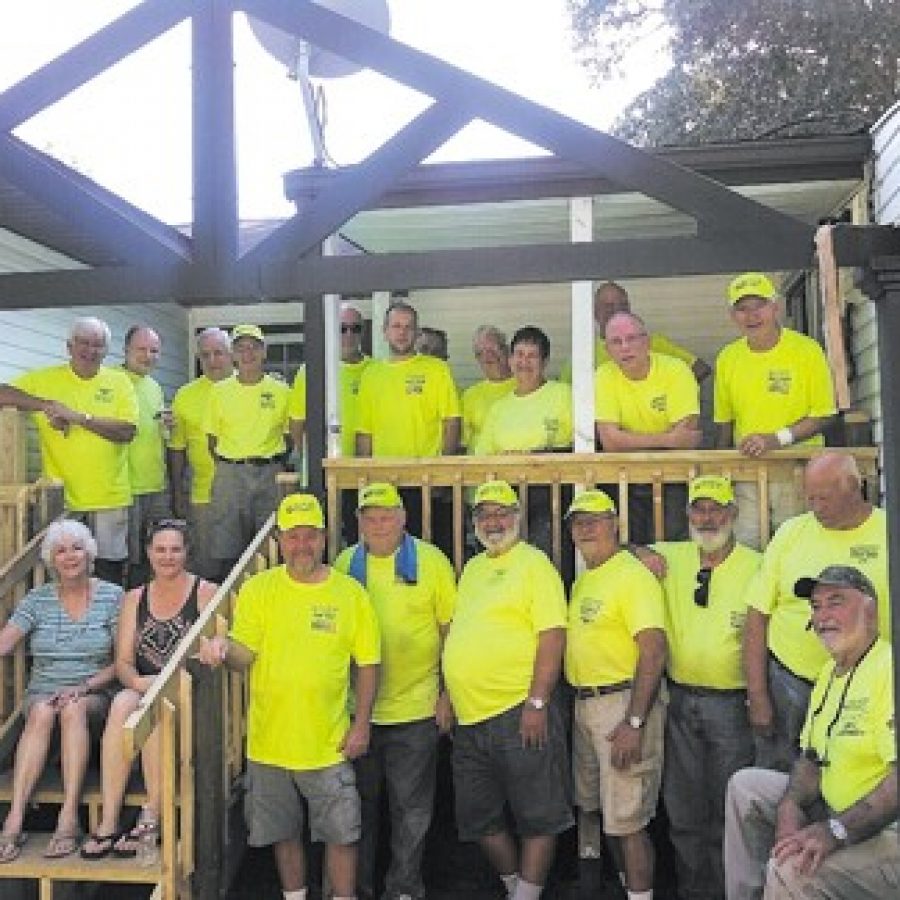 Members of the St. Louis Sluggers from the Queen of All Saints Catholic Church are pictured on the newly constructed back porch of the home they worked on near Shoal Creek.