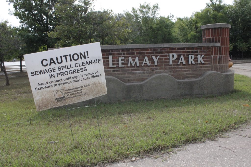 A sign urges residents to avoid contact with remaining floodwater in Lemay Park June 21. Floodwaters may carry sewage and infectious organisms.