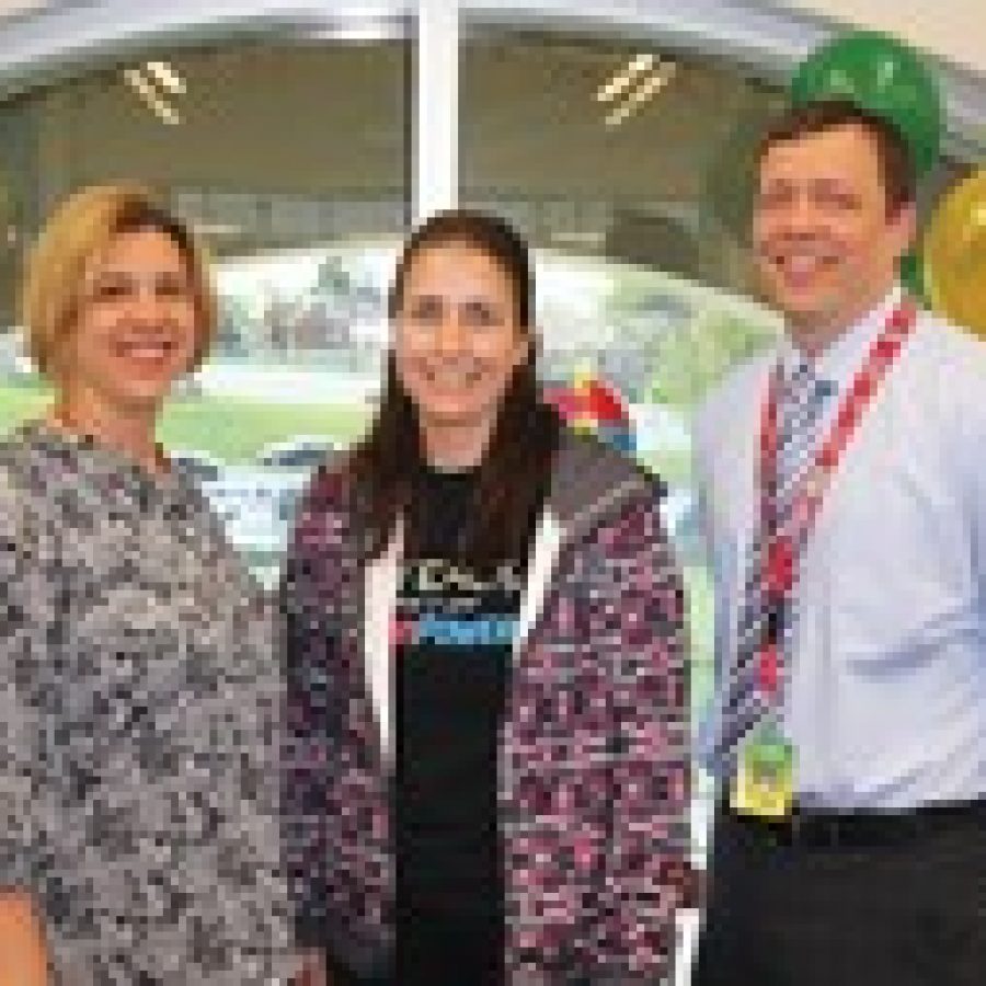 Sappington Elementary Principal Craig Hamby, right, and Administrative Intern Angie Moehlmann, left, congratulate physical education teacher Mary Driemeyer on being named Lindberghs 2014 Teacher of the Year. 