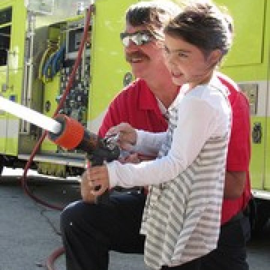 Long Elementary School kindergarten student Rosie Grebe takes her turn spraying a fire hose during National Fire Prevention Week. The Crestwood Fire Department visited Long and Crestwood elementary schools to talk with students about fire safety. 