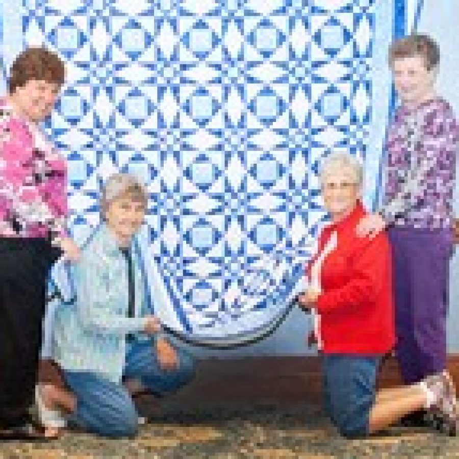 St. Dominic Savio quilters, from left, Eileen C. Bunse, Hilda Ruppe, Dion M. Scherr and Anna Marie Krauska, lovingly prepare for the process of taking down their quilt after winning Fountain Views Fifth Annual Quilt Contest and a \$1,000 check. 