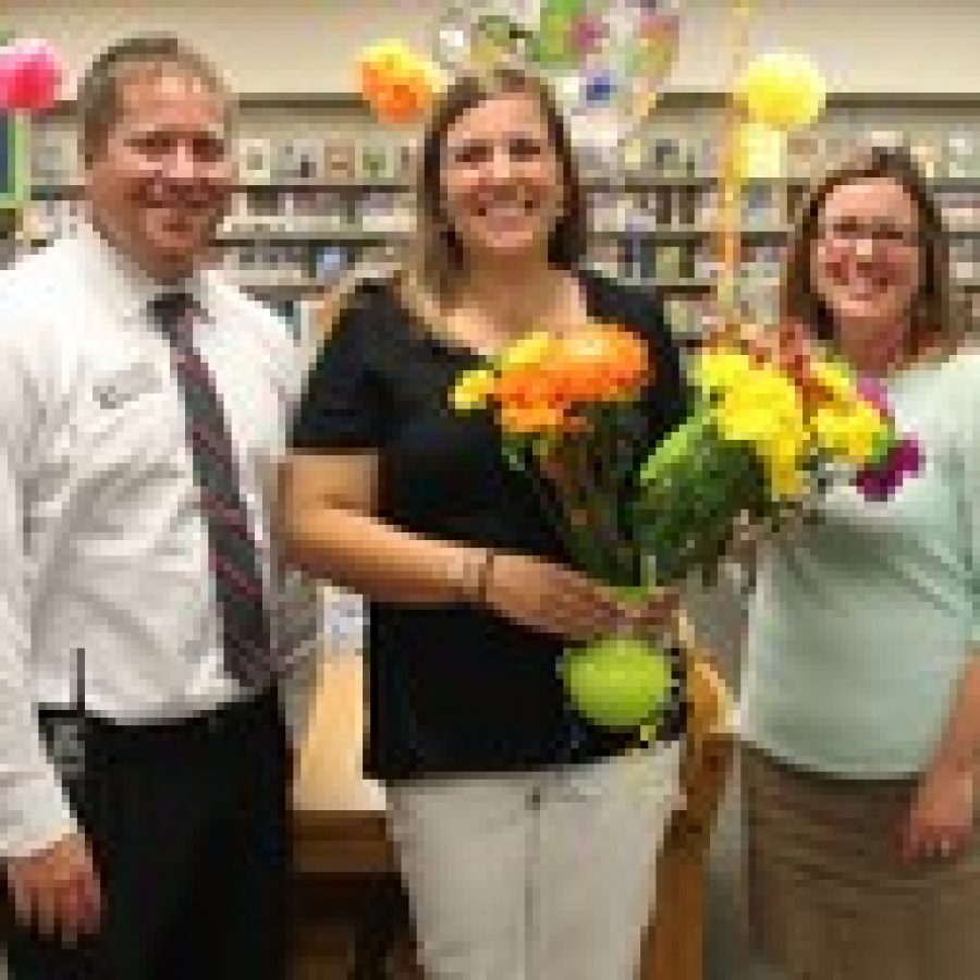 Truman Middle School science teacher Melissa Nussbaum, center, is congratulated by Principal Tara Sparks and Assistant Principal Mike Straatmann during a surprise announcement.
 