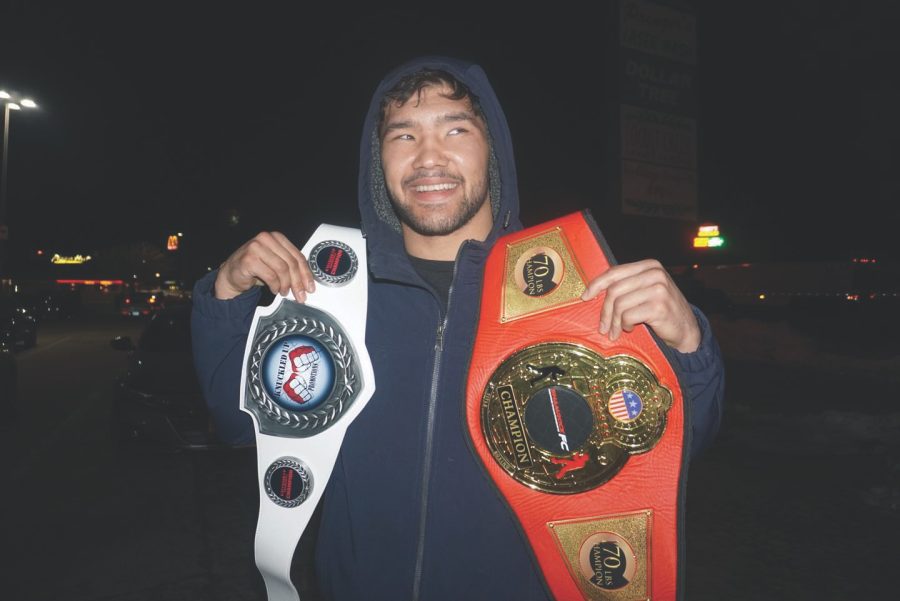 Max Choriev poses with his title belts after his win on Jan. 22.