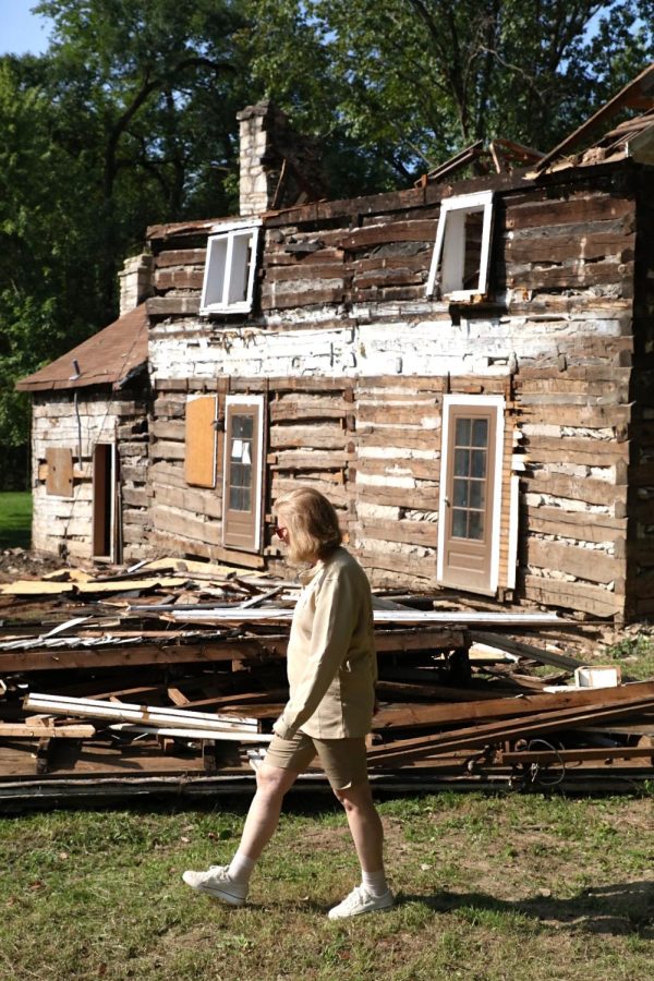 Thomas Sappington House Resident Manager Sally Cakouros walks past pieces of the Joseph Sappington Cabin’s roof during its dismantling Sept. 13.  