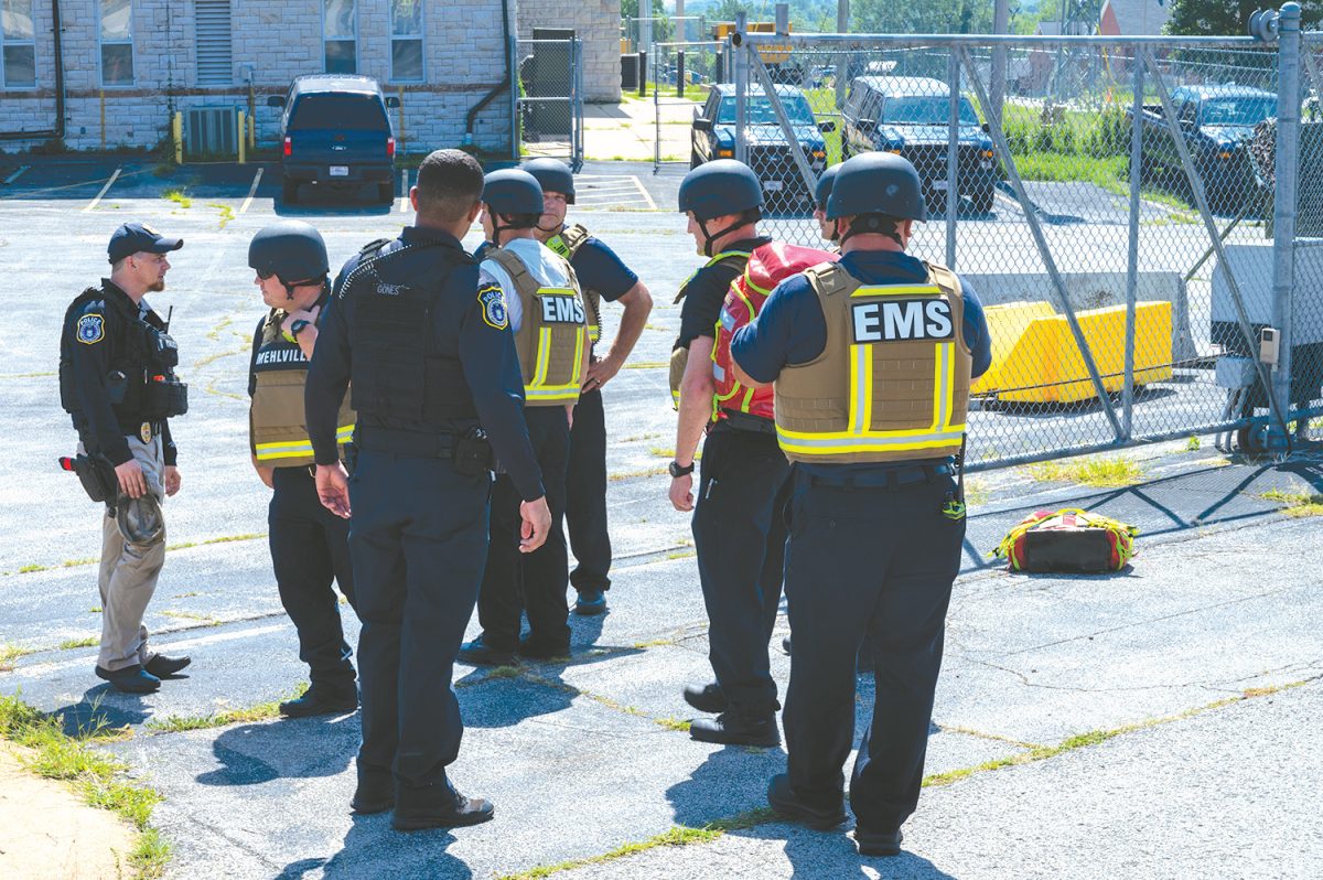 Officers with the 131st Security Forces Squadron and members of Mehlville Fire Protection District wait for mock victims to be extracted from a building during a simulated active shooter event, Jefferson Barracks Air National Guard Base, Mo., Aug. 11, 2023. The two organizations worked together over multiple days to train and test their capabilities. Photo by U.S. Air National Guard Tech. Sgt. Stephanie Mundwiller.