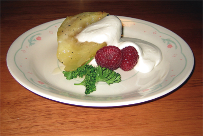 Pears poached with vanilla, honey and white wine, garnished with mascarpone, brandy and raspberries. 