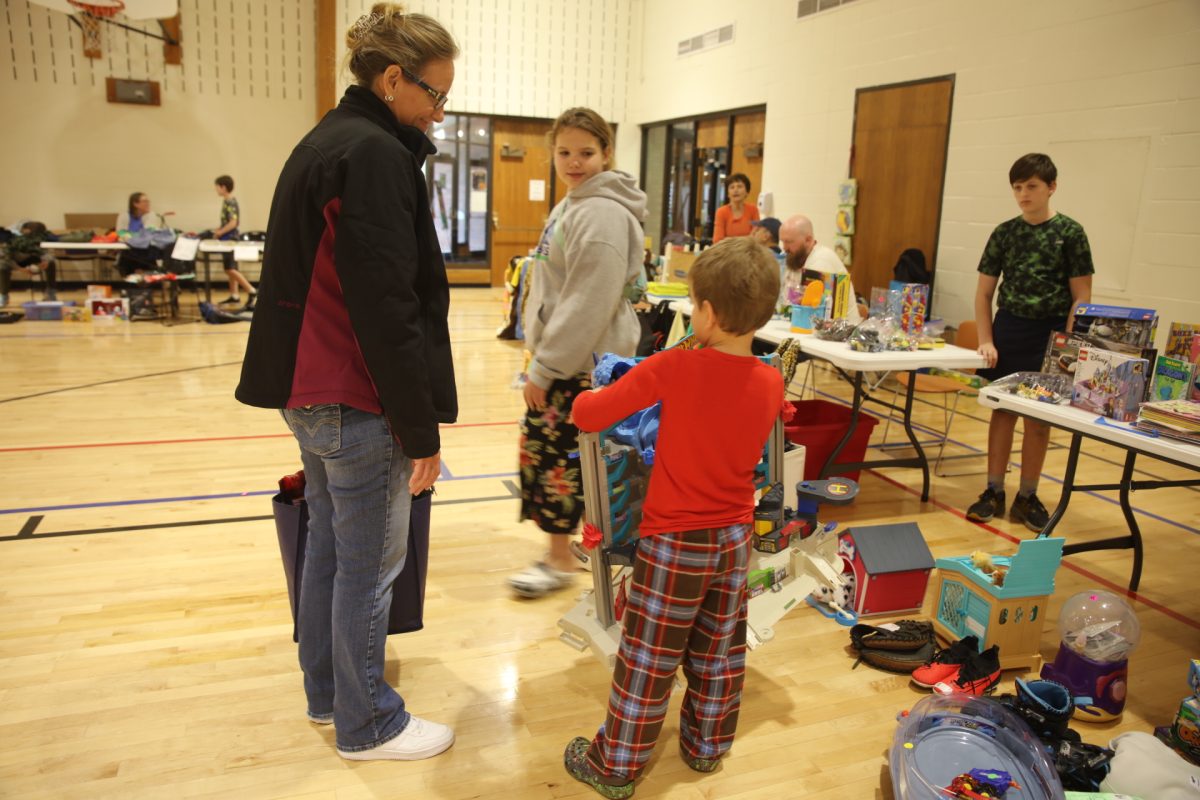 A child carries his newly purchased toy from the 2024 Crestwood Kids Garage Sale.