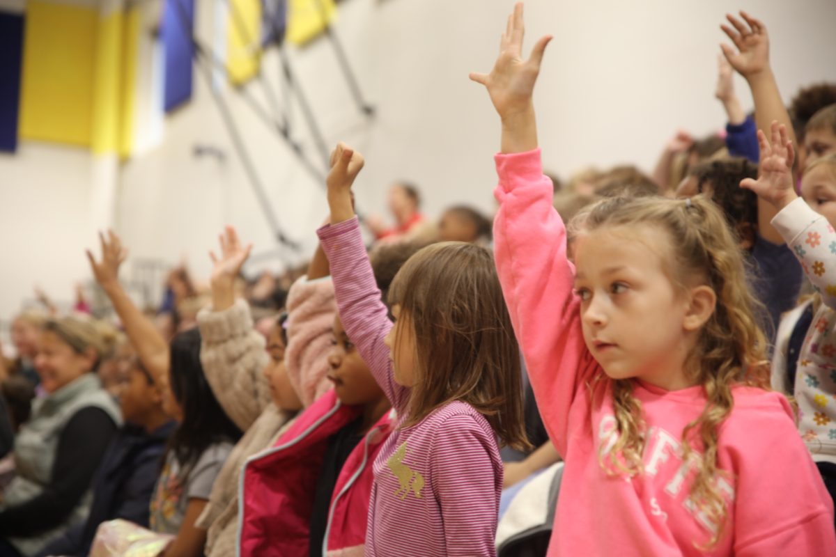 Hancock Place Elementary School students raise their hands when asked if they know how to ride a bike.