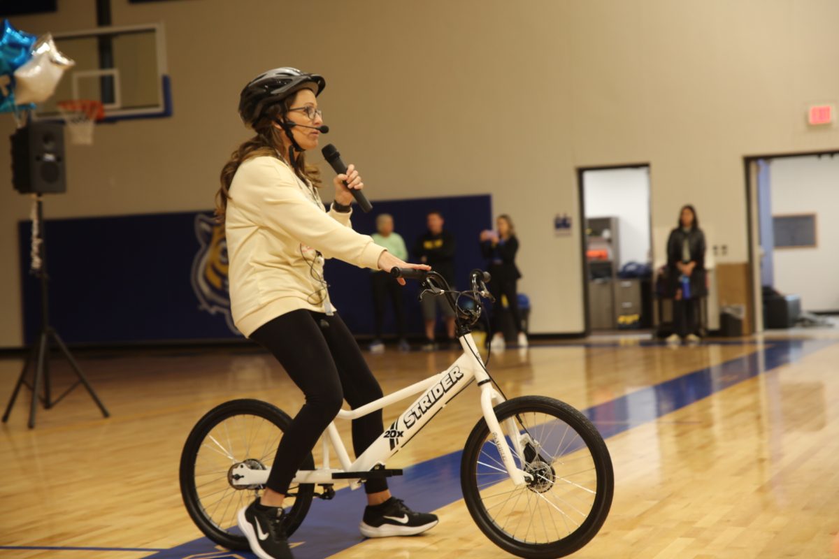 Marcie Reeves, PE teacher, demonstrates how to use the Strider balance-to-pedal bikes.