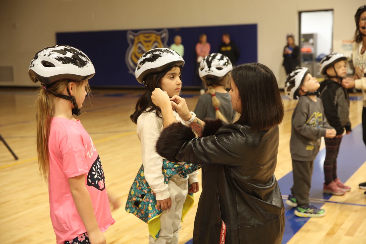 Before riding the new bikes, students put on helmets.