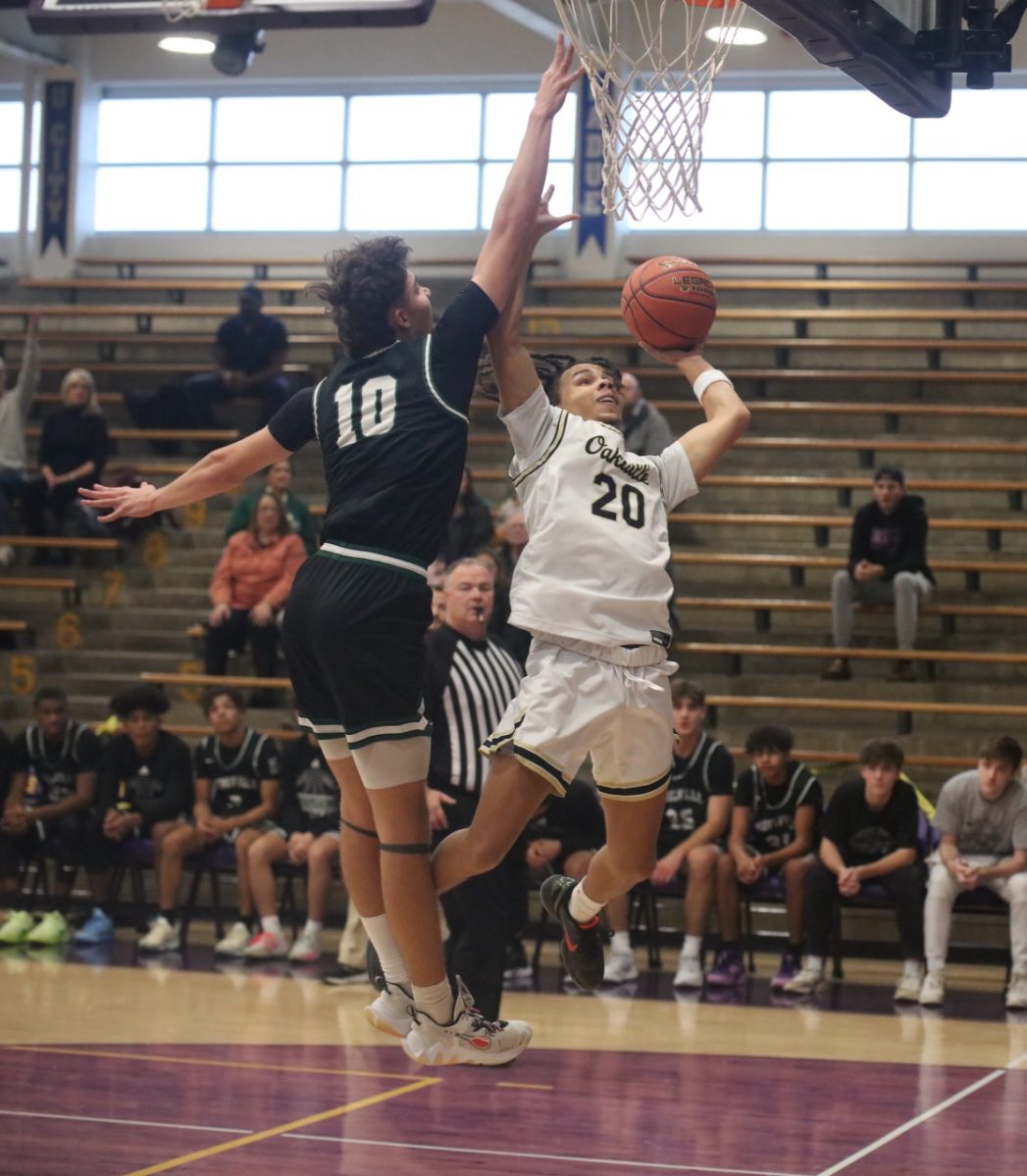 Mehlville player Josh Williams (10) attempts to stop Oakville forward Elijah McDaniel from a layup.