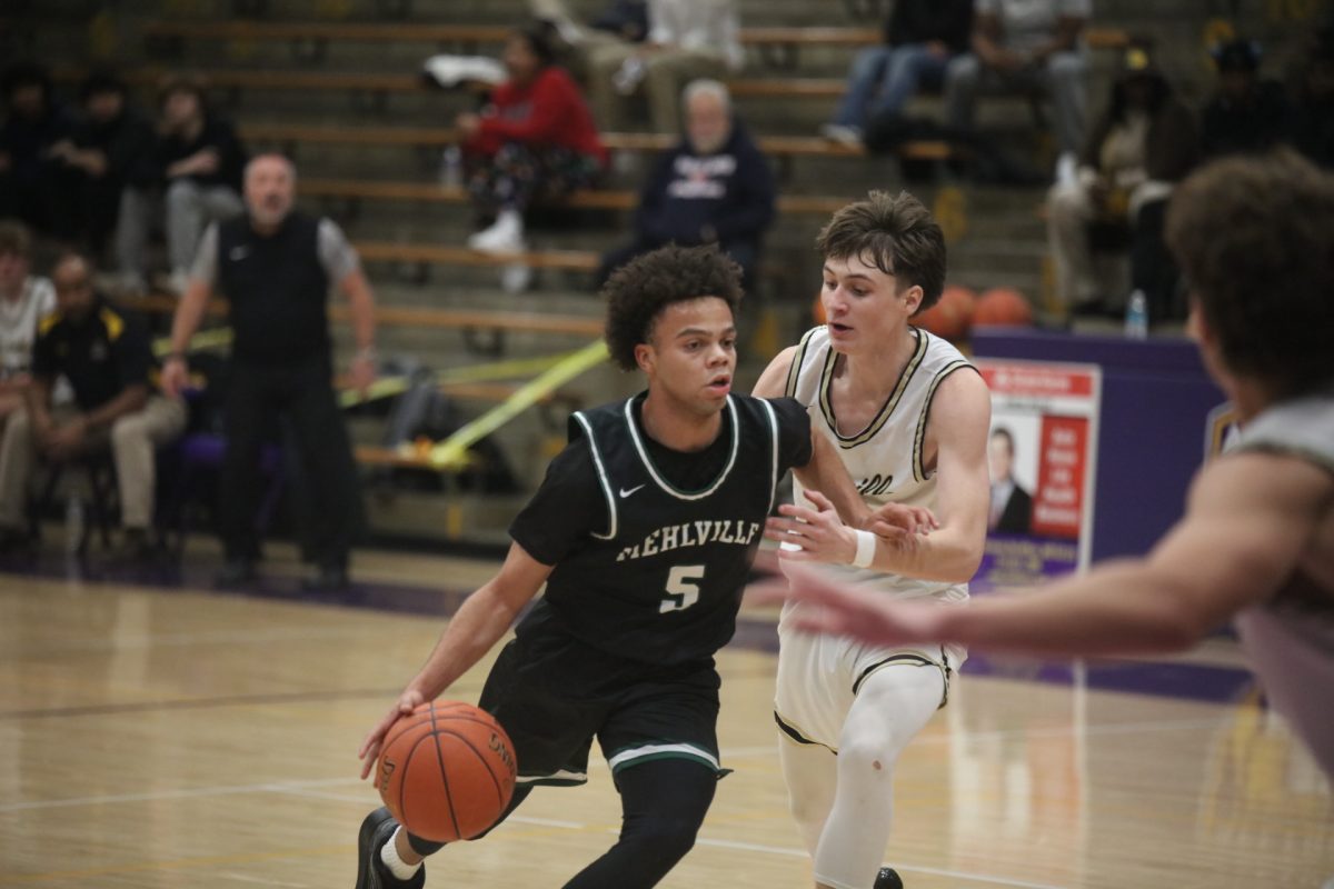 Mehlville's Marcus Jacobs (5) rushes aggressively down court, shrugging off an Oakville player with an arm bar.