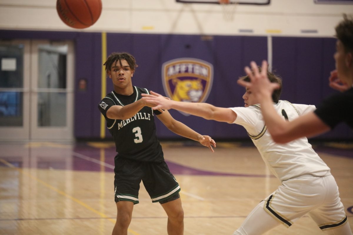 Mehlville player Jordan Hannam-Lewis passes the ball with one arm to his teammate before an Oakville player can block.