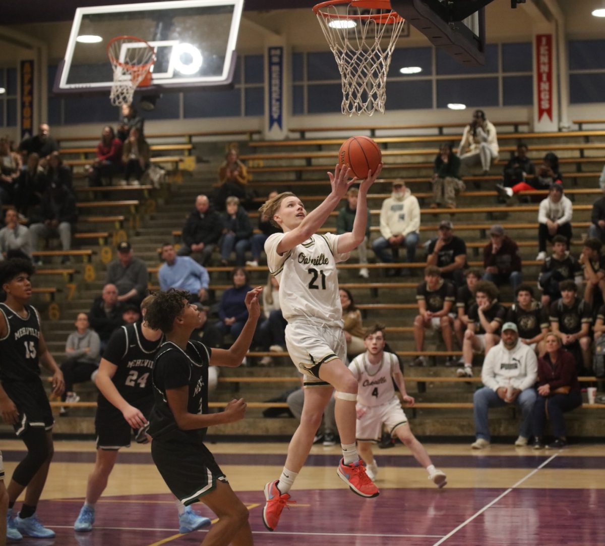 Oakville Guard Cameron Gibbs  (21) leaps for a layup as Mehlville players follow behind.