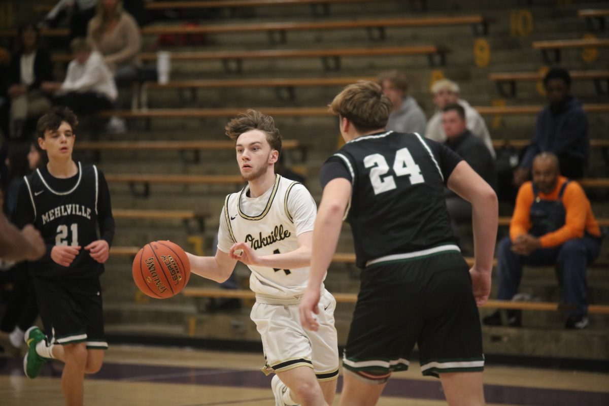 Oakville guard Jack O'Connell with the ball moves down the court looking for someone open as Mehlville player Preston Lawrence covers him.