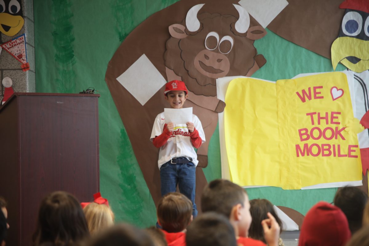 A baseball-loving student from Bierbaum Elementary School introduces former Cardinals Player Brad Thompson, emcee of the bookmobile unveiling event.