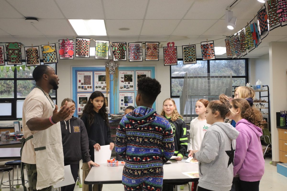 Darrion Cockrell, Crestwood Elementary School's physical education teacher, tells ten selected fifth graders that their self-portraits will be sent to the White House and used as holiday decor. 