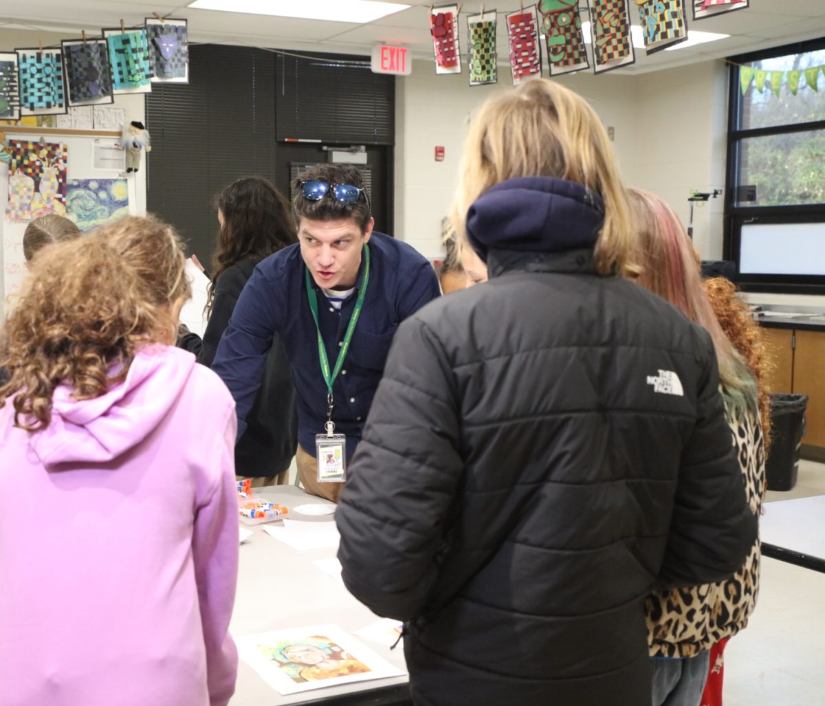 Crestwood Elementary School art teacher Christopher Burke explains how to create the ornaments from the students' already-made self-portraits. 