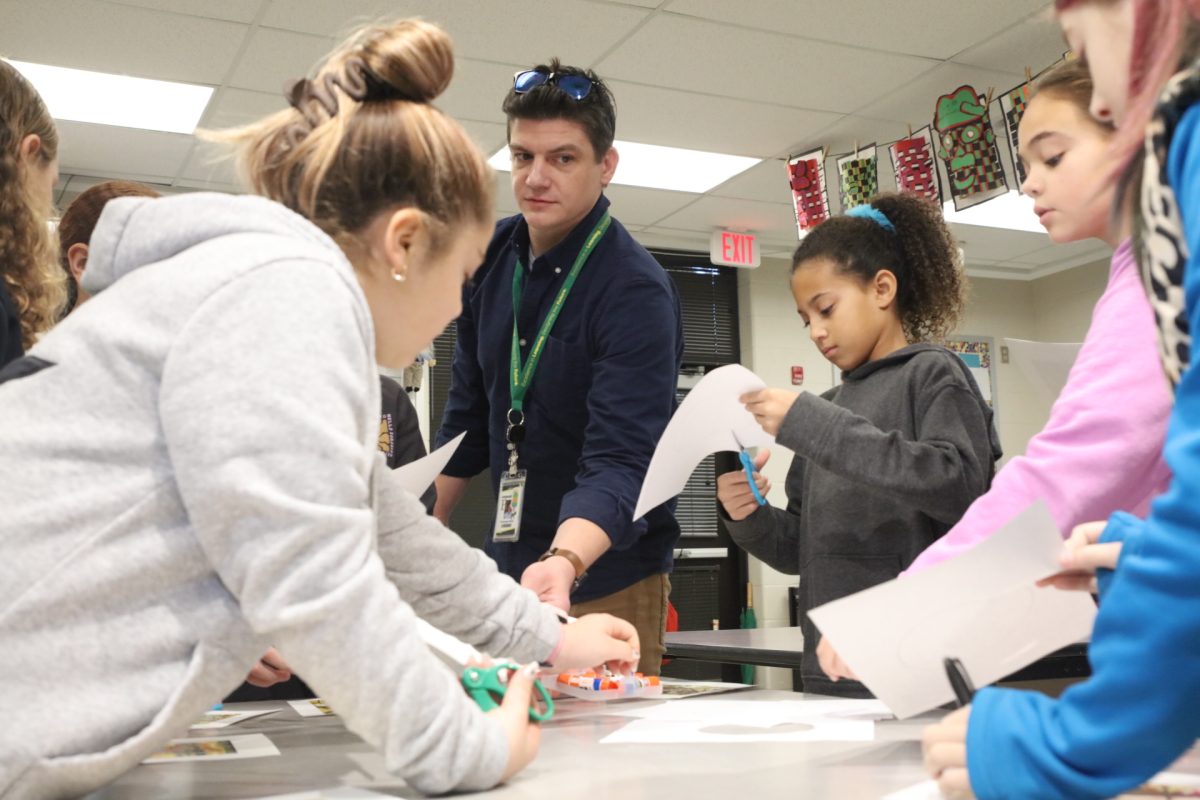 Students trace, cut and paste their ornaments after receiving instructions from Crestwood Elementary School art teacher Christopher Burke.