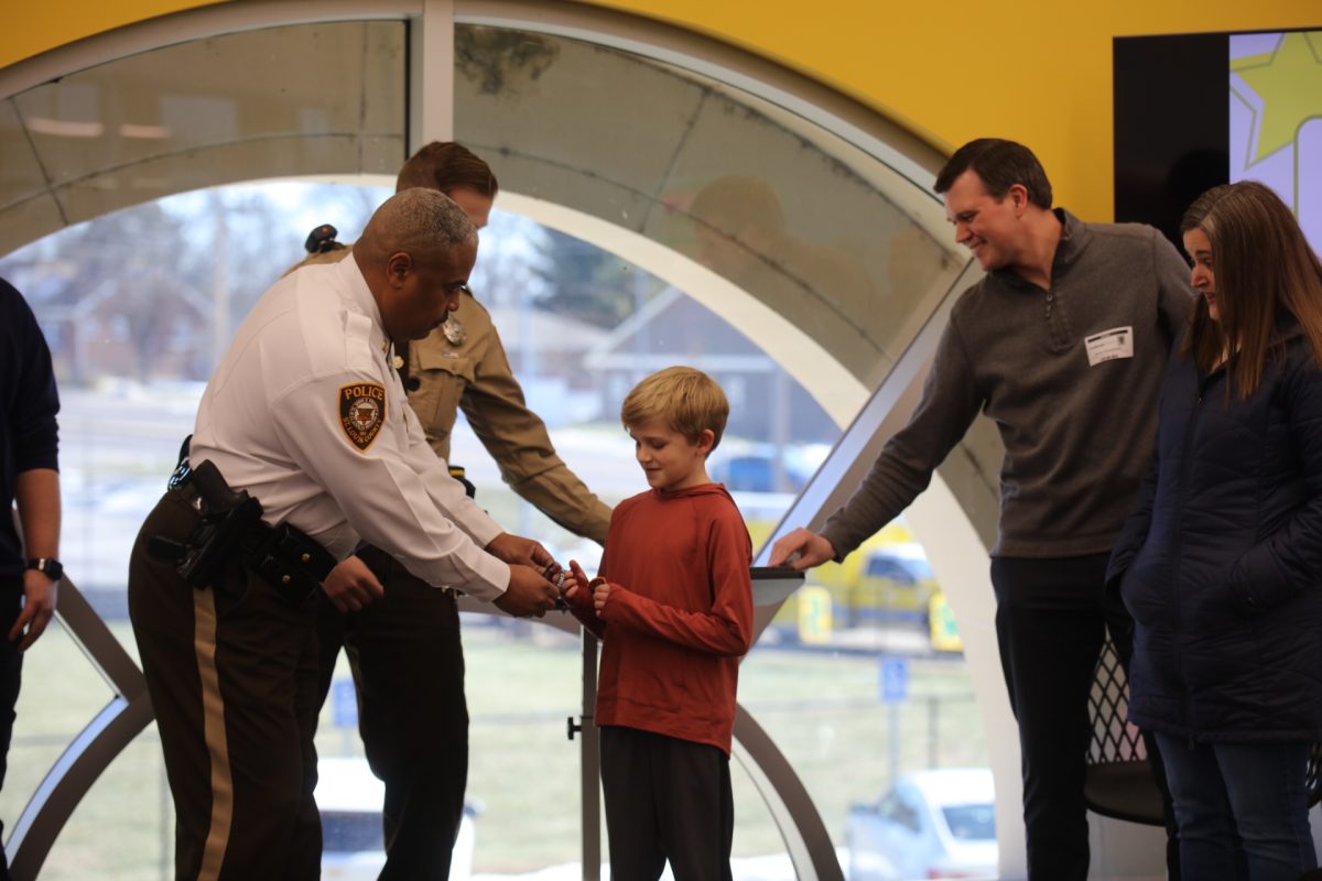 Affton-Southwest Precinct Commander Captain Guy Means gives Max an honorary police badge, police patch and police chief bracelet. 