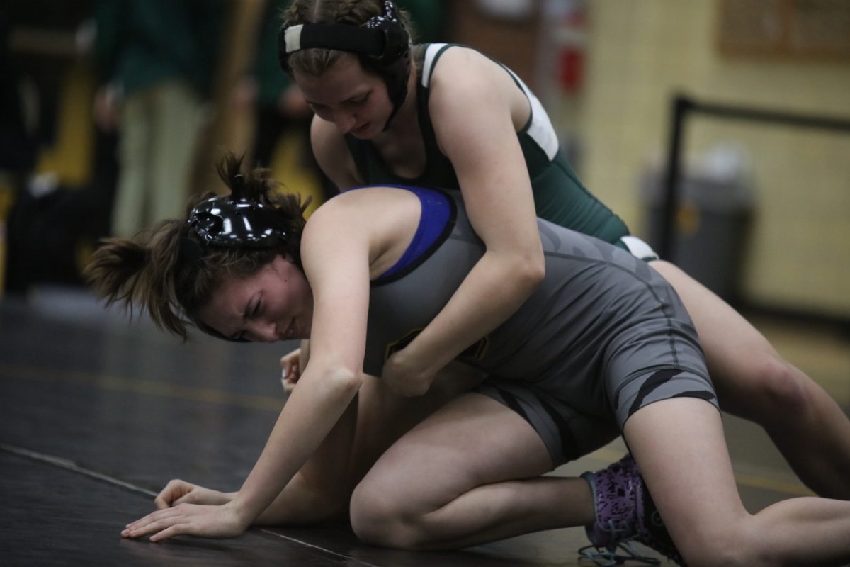 A Lindbergh wrestler keeps dominance, holding her Oakville opponent around the torso.