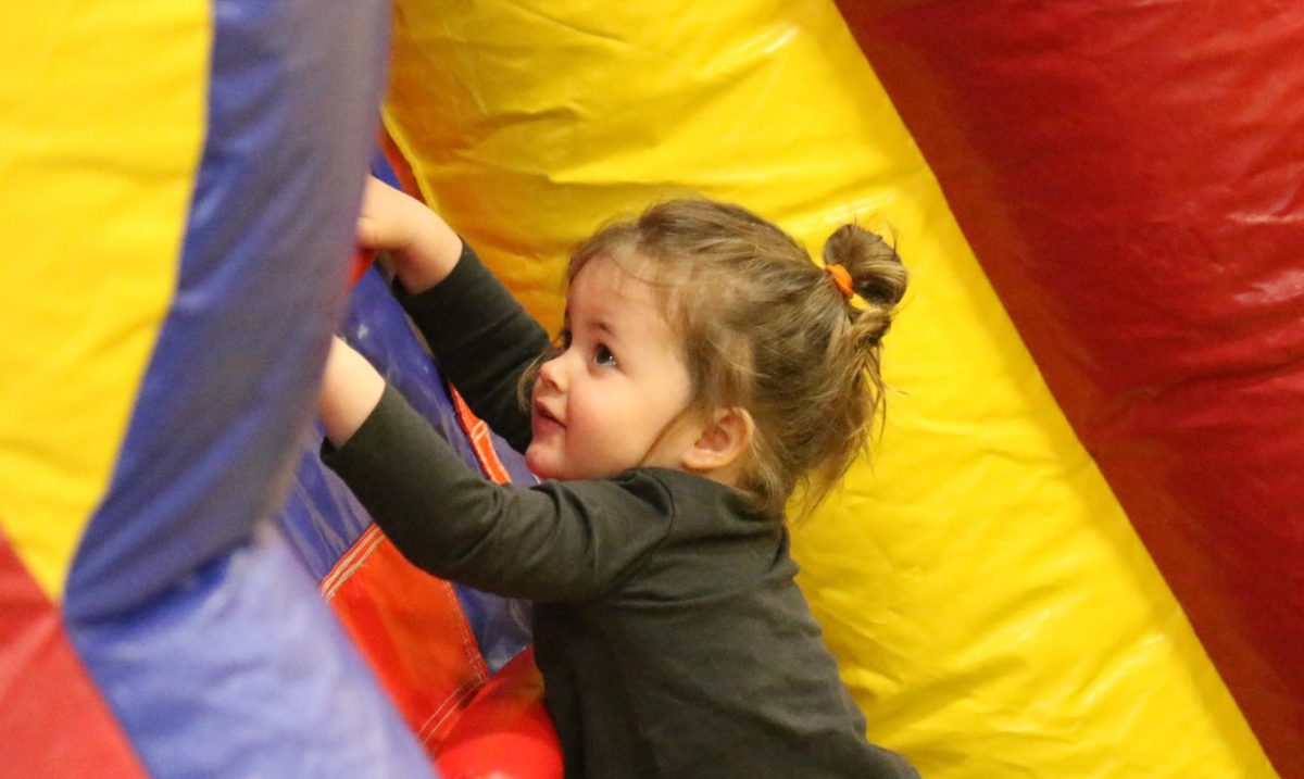 A young Winterfest attendee climbs up an inflatable playset.