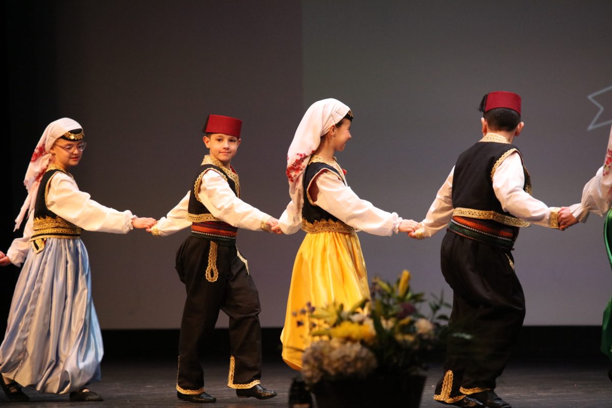 The young performers are led off stage holding hands.