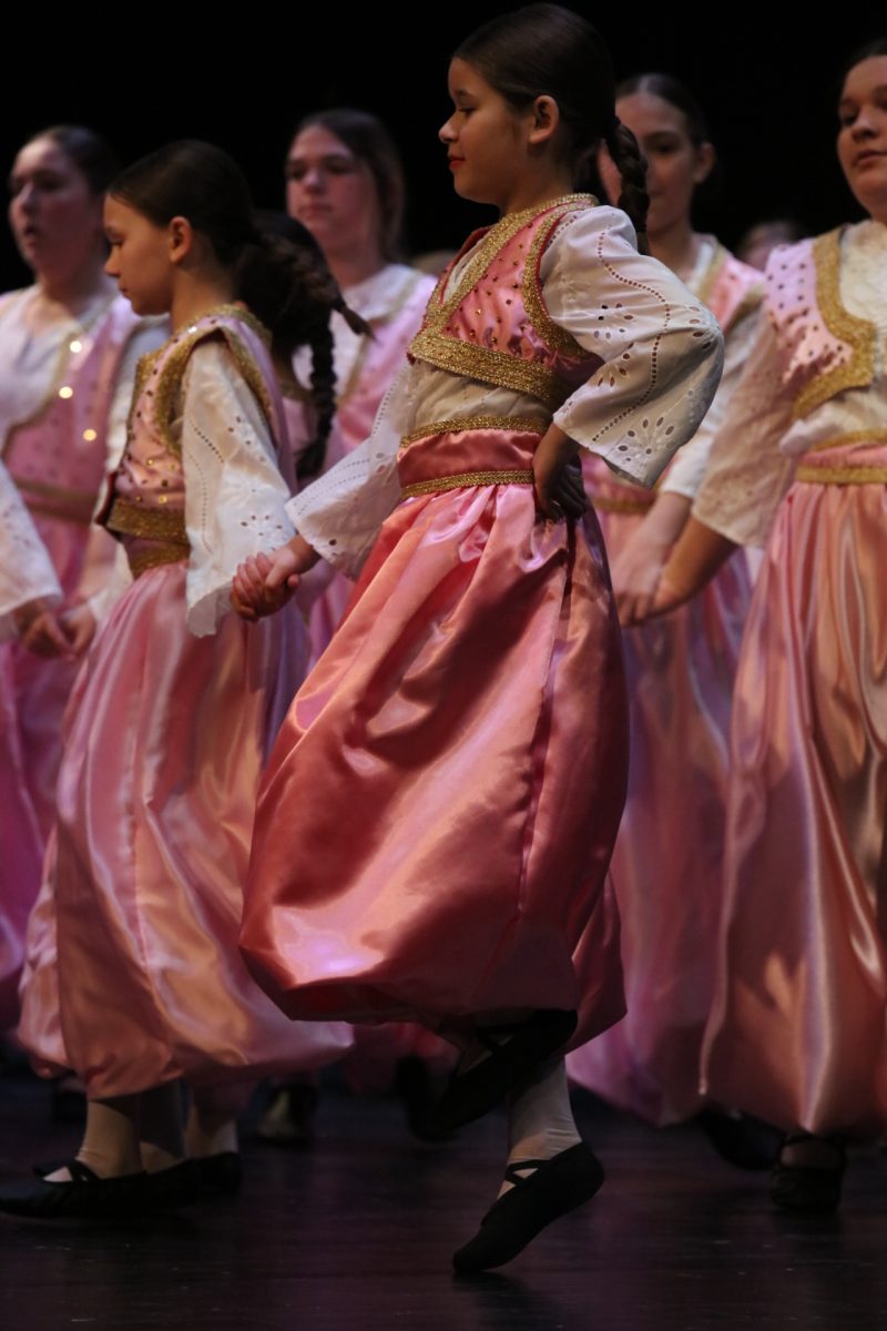 A young performer balances on one foot.
