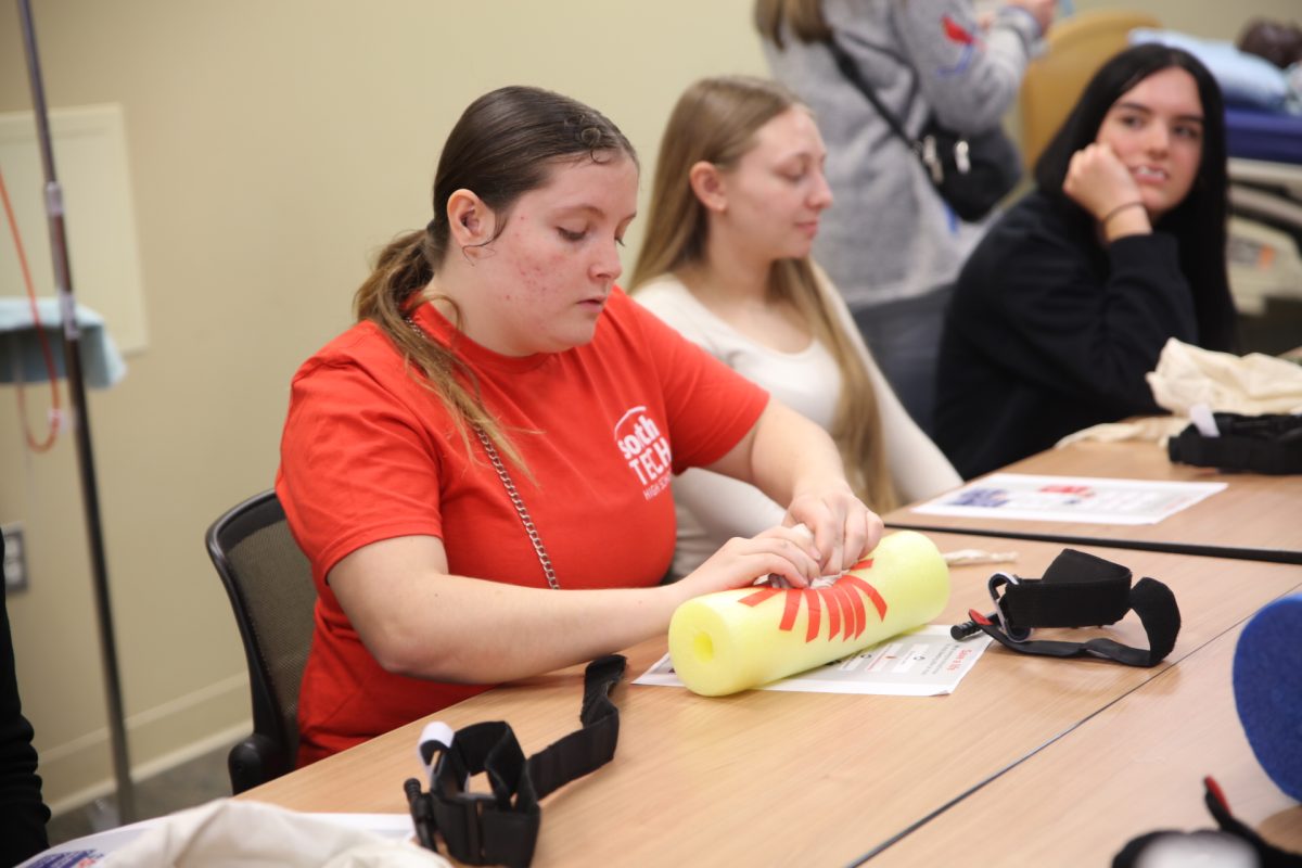A student practices packing a wound.