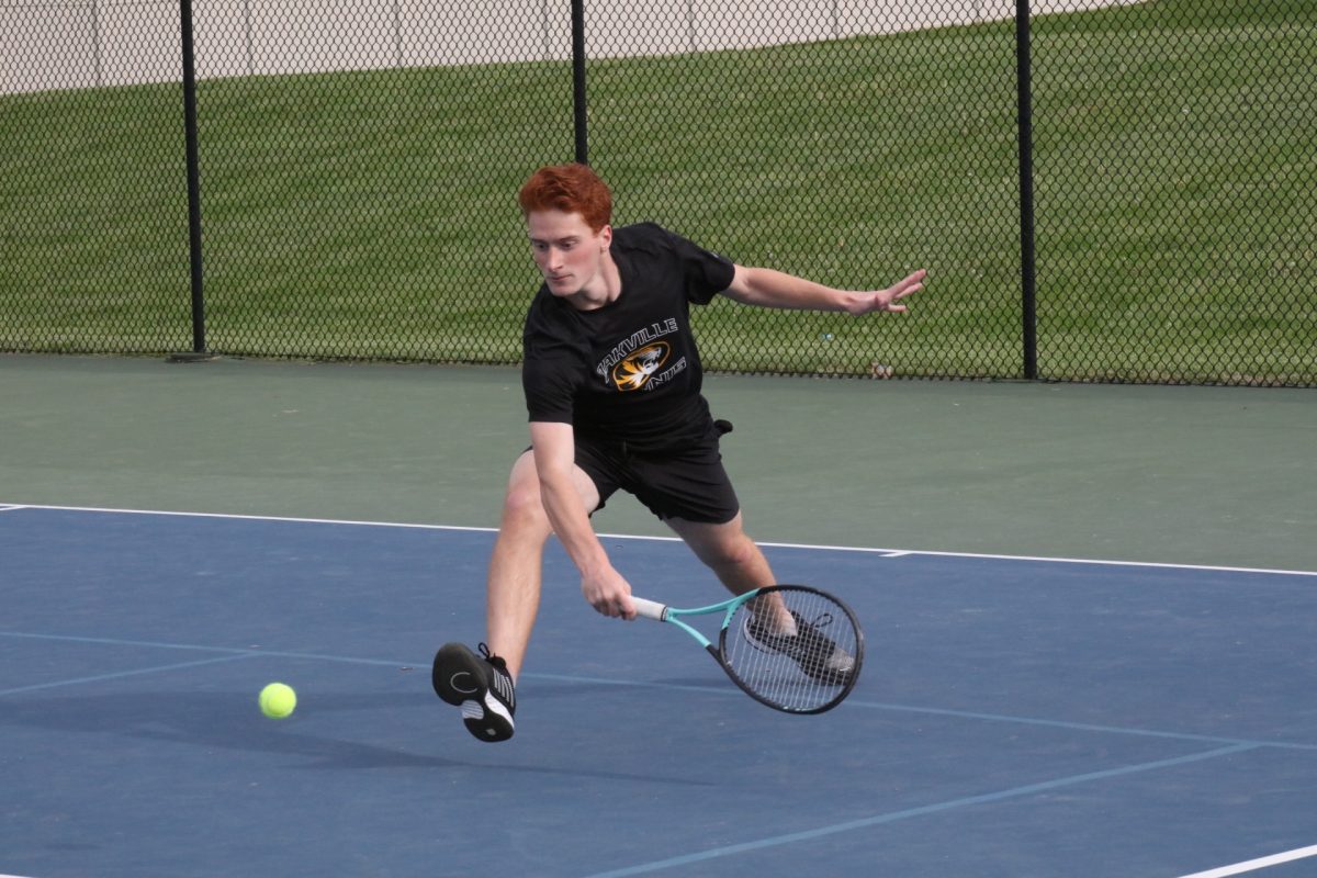 An Oakville player swings low while running to get a shallow ball.