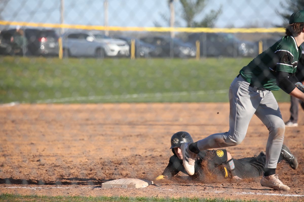 An Oakville player slides to safety.