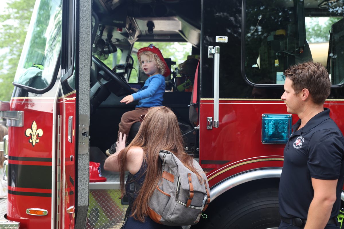A young attendee sits in a fire truck.