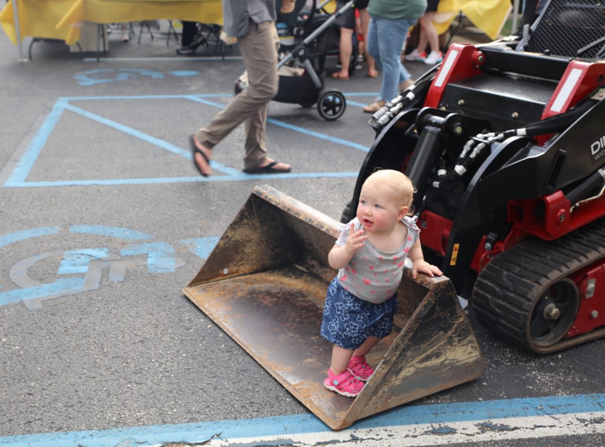 A baby stands in a loader.