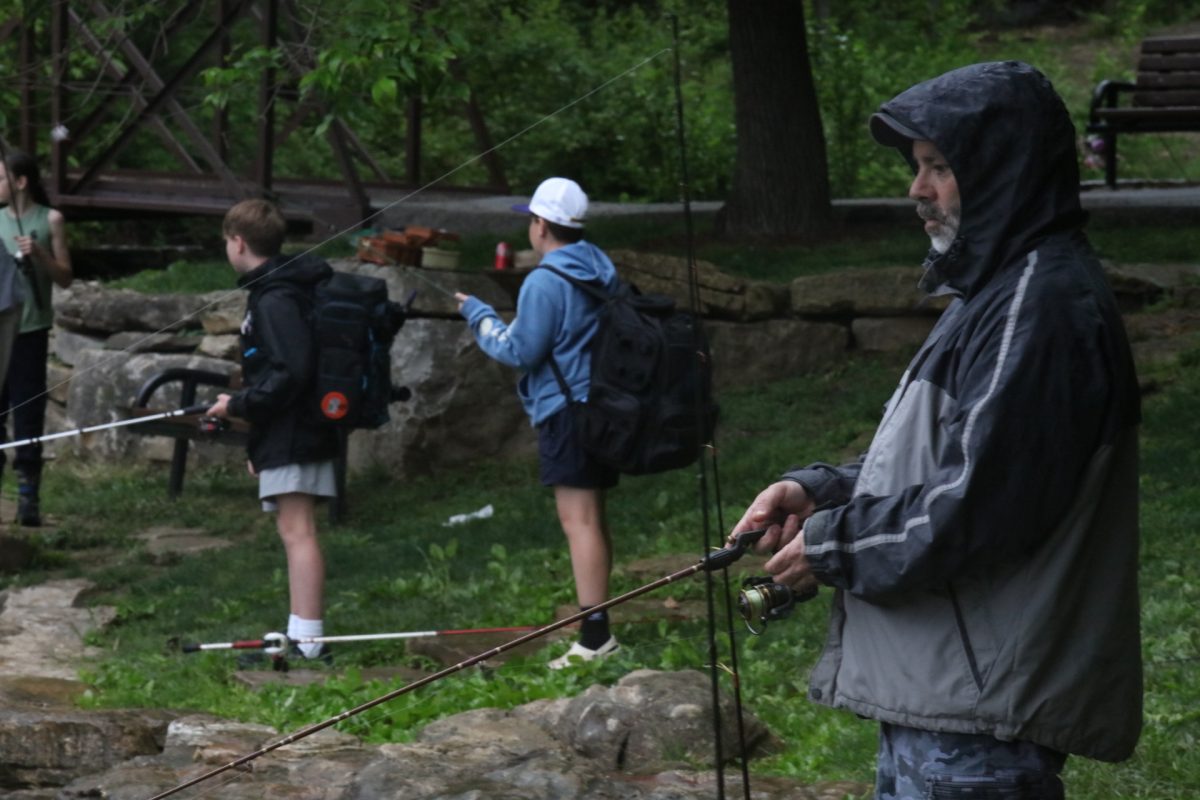 A fishing derby attendee concetrates on his rod. 