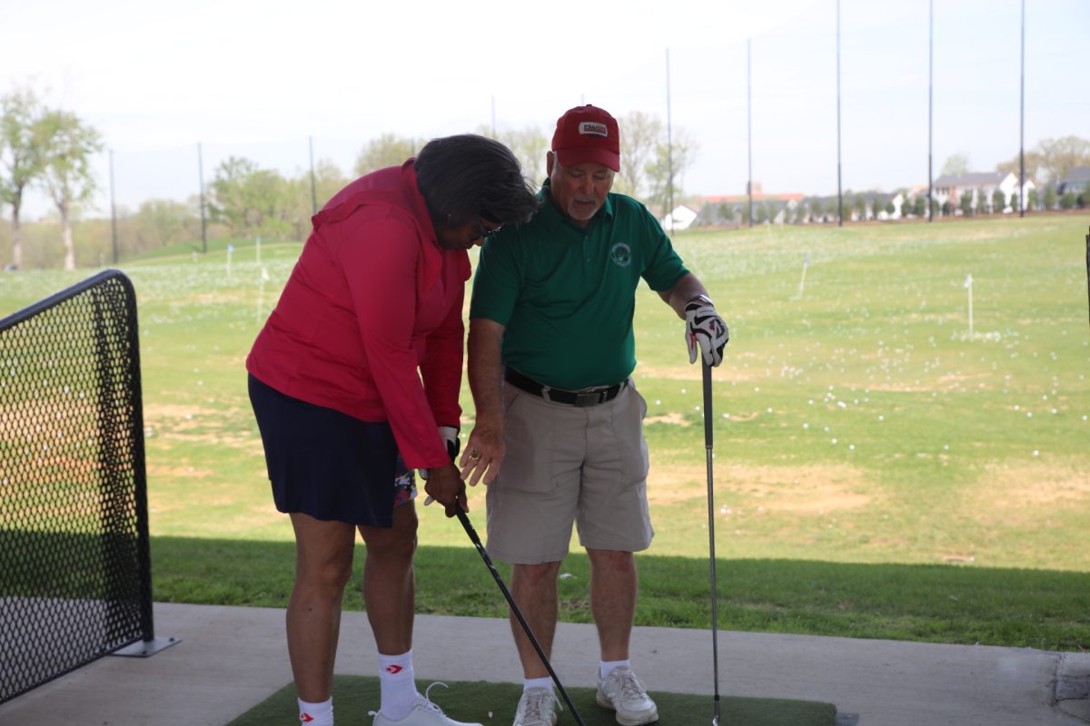 Veteran and PGA HOPE instructor Tim Davenport helps a participant with her golf swing at the April 23 clinic held at Tower Tee, pictured above. When asked about his favorite part of the program, Davenport, who has been involved with PGA HOPE since it began, said: “The smiles.”
