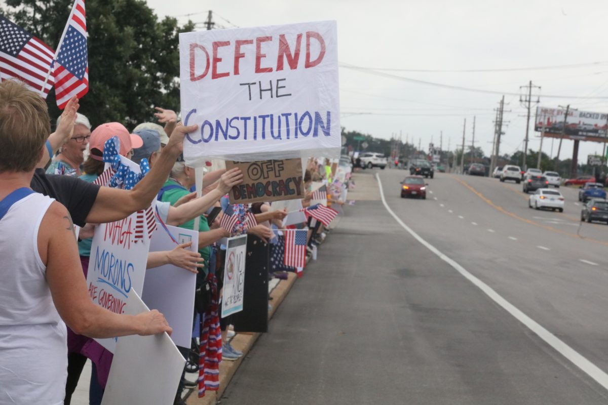 Protestors display their signs to oncoming traffic.