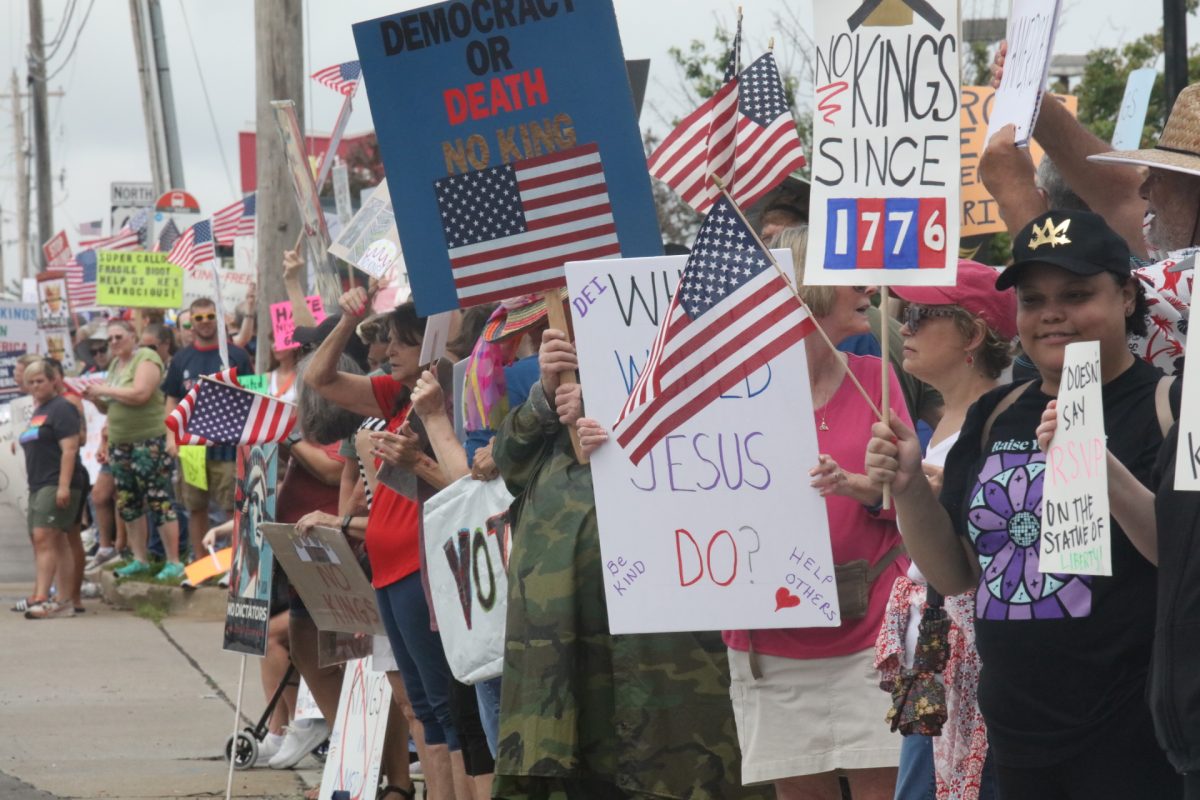 Comunity members hold up homemade signs at the "NO KINGS" protest held on June 14.