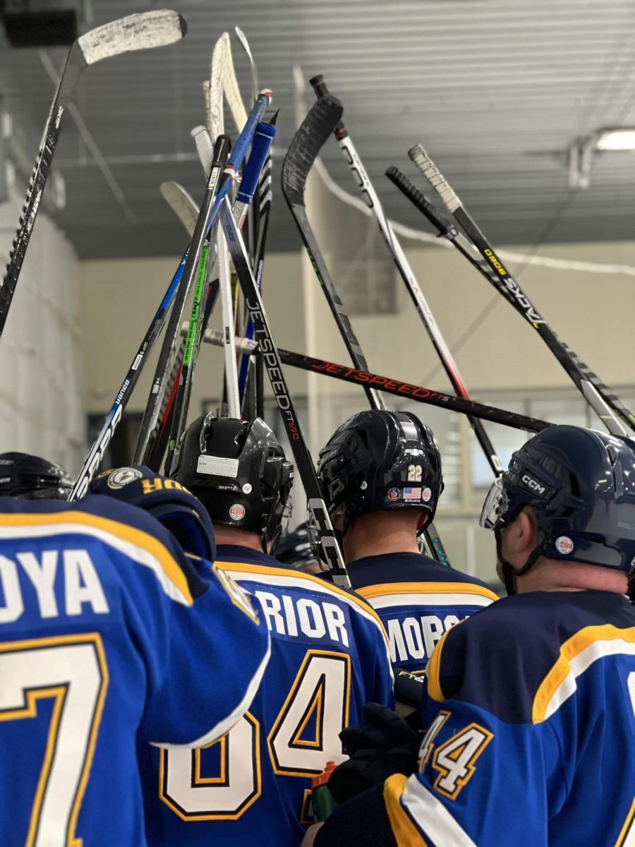St. Louis Blues Warriors hockey players hold their sticks in the air. Photo courtesy of Liz Reily, Next PR.