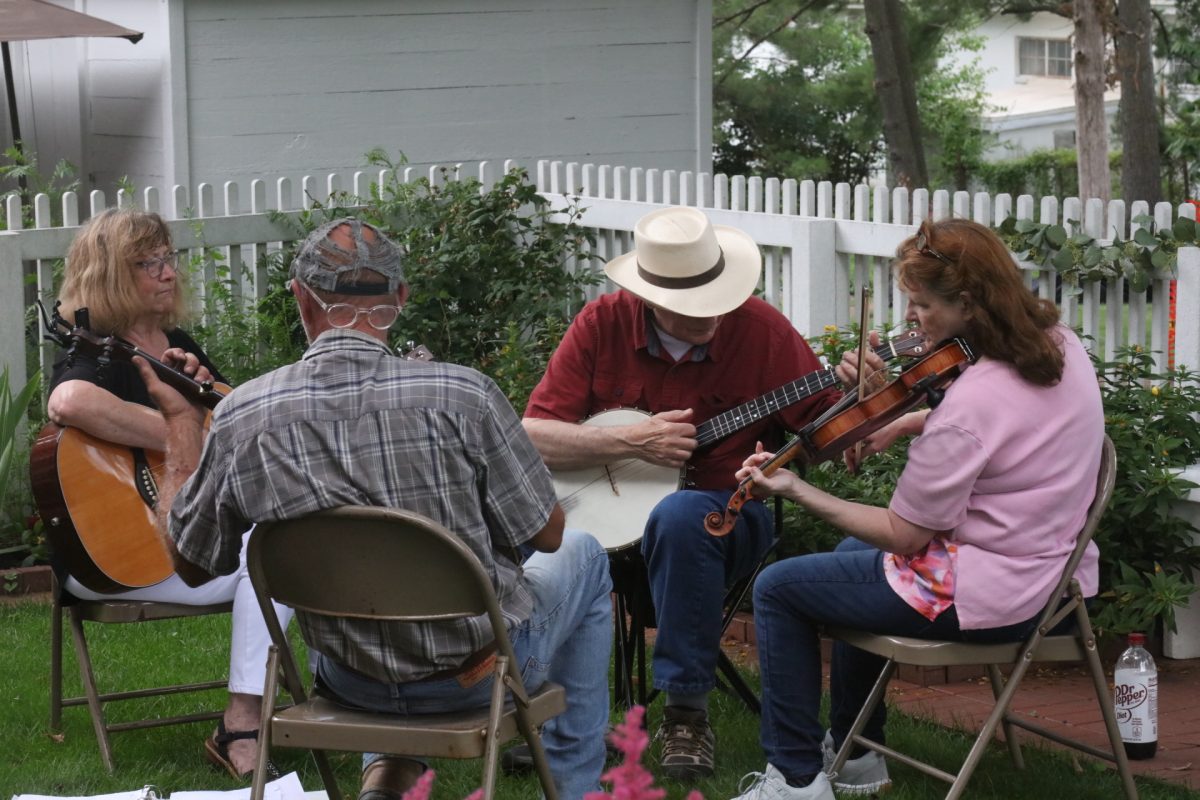 A band plays live music in a circle in the garden for the community to enjoy.