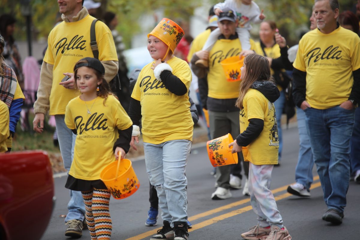 Children and adults wearing shirts for Pella Windows and Doors marched in the 2025 SunCrest Fest parade.