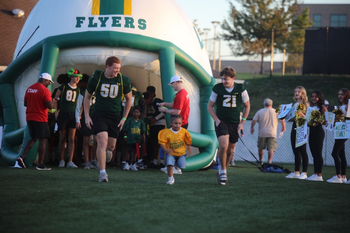 Children, accompanied by LHS students, ran through a walkway of cheering onlookers after being introduced.