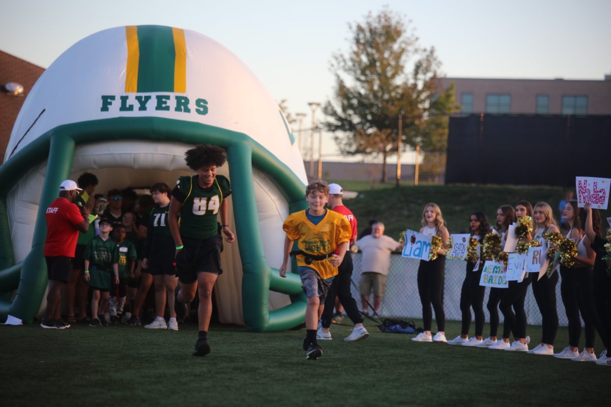 Children, accompanied by LHS students, ran through a walkway of cheering onlookers after being introduced.