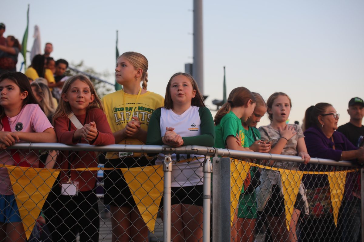 Fans in the stands wait for the flag football game to start.