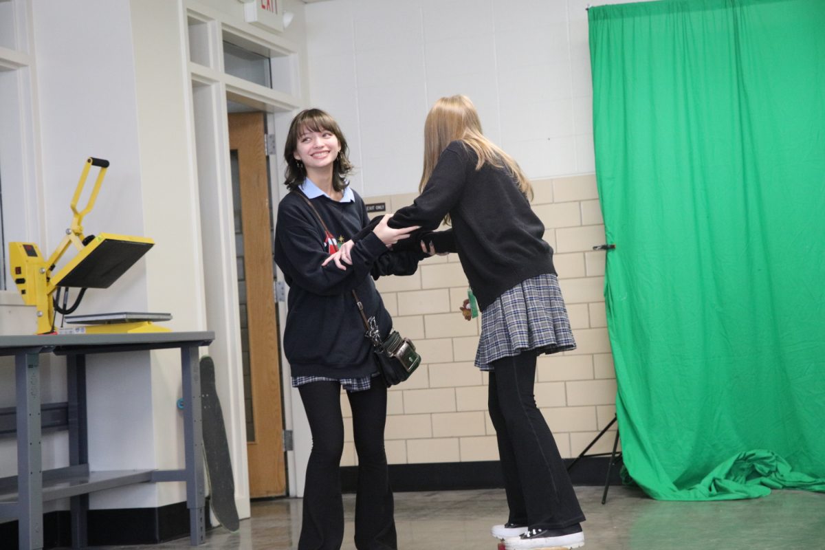 Kehaumailani Breitenfeld assists a fellow Skate Club member, providing guidance and stability.