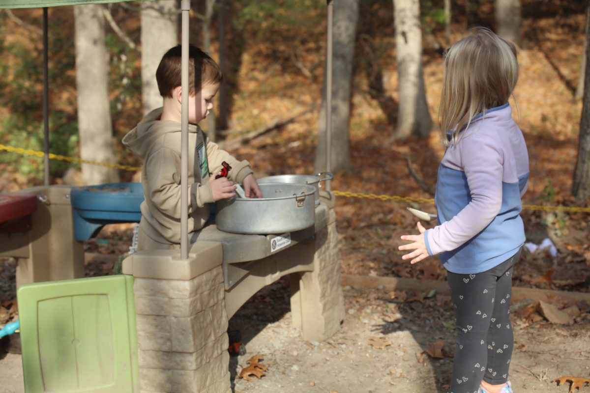 John Cary Early Childhood Center students "cook" with dirt and mud, using shovels as spatulas and spoons.